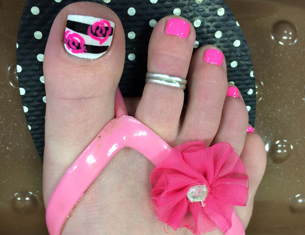 A woman's predominantly pink post-pedi look with nail art from Binh's Nails in Edmonton's East End