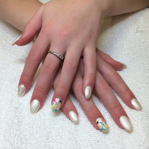 Smooth young hands with polished nails in white with Asian-inspired designs on the ring fingers from Binh's Nails
