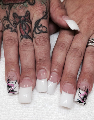 White nail polish on extra-long nails and design elements on the ring fingers makes a powerful statement at Binh's.