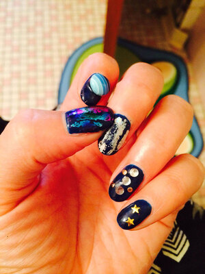 5 fingers each with a startingly different design including stars, planets and other celestial elements produce an eye-catching style from Edmonton's Binh's Nails