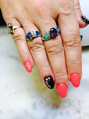 A female hand adorned with jewelrey that matches the 3D nail stylings applied by Binh's Nails artistic technicians