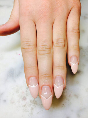 A well-manicured woman's hand with carefuly shaped fingernails and matching polish with a V design from Binh's Nails