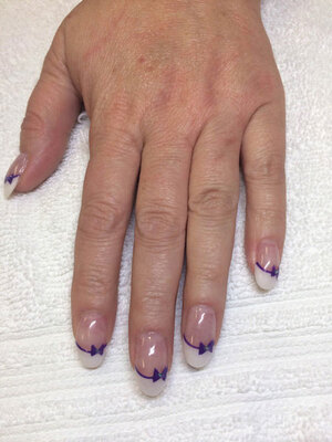 A feminine hand featuring oval nails with a matching bowtie motif is a great look available from Binh's Nails on 17 Street in Edmonton.