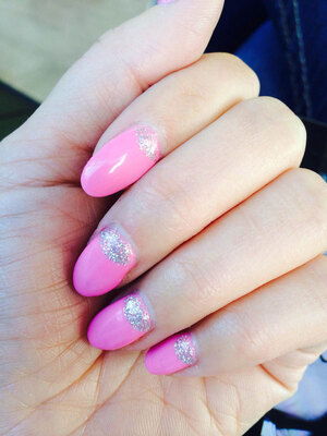 A hand featuring pink nails with glitter cuticle accents make a lovely look from Binh's quality manicurists