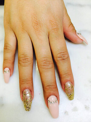 Oval gel nails artistically decorated with gold glitter, polka dots and jewel appliques create fabulous finger fashion designs at Edmonton's finest nail salon; Binh's.