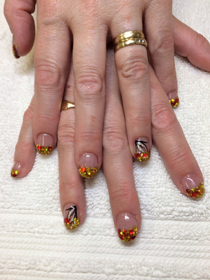 Female fingers decorated with gold tips and contrasting ring finger designs created by Binh's manicurists