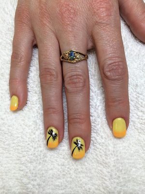 Fingernails painted yellow with tiny palm trees painted on the two middle fingers are a great finish from Salon Binh's in Edmonton
