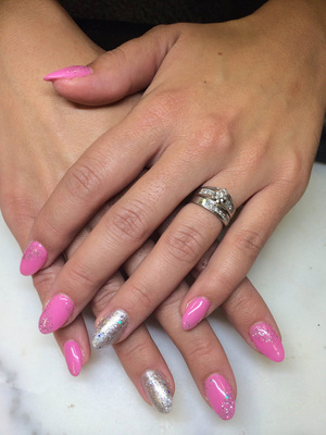 Pink polish with contrasting ring-finger hue and glitter makes an attractive presentation from Binh's Nail salon.