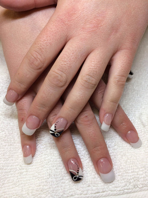 Feminine hands with French tips on the fingernails and styled design on the ring fingers is a terrific combination at Binh's manicures and pedicures.