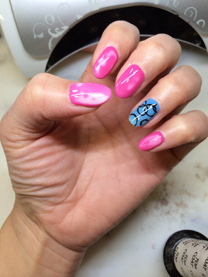 Pink polish on female fingernails are adorned with white accents and contrasting ring-finger design from Binh's Nail Salon in Edmonton