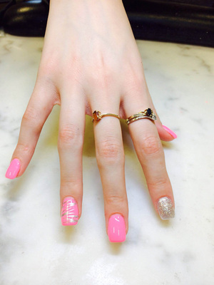 Youthful-looking hands with pink nail polish and unique white flourishes on each finger