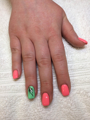 Pink polished fingernails are contrasted by pistachio polish on the ring fingers in this attractive Binh's salon style