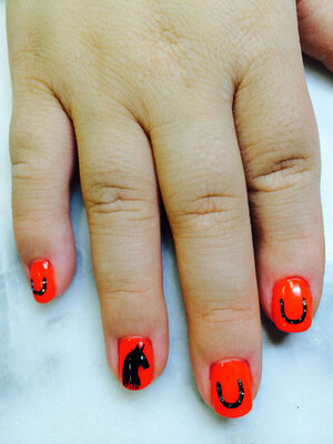 Female fingernails painted bright orange with horseshoes and a stallion's head stylings are a standout look from Binh's in East Edmonton.