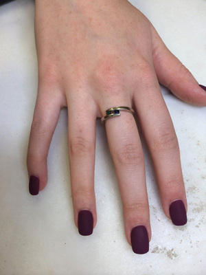 A single female hand highlighted by dark purple polish from the nail stylists at Binh's.