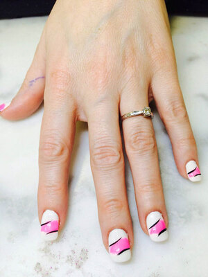 This young woman's hand with squared nails featuring a white, black and mauve design was styled by Binh's expert manicurists.