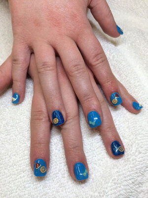 A pair of hands with squared nails in light and dark blue with sailing imagery creates a unique style from Binh's in Edmonton