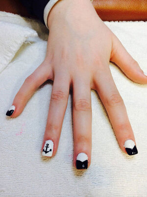 A displayed feminine hand displays B&W squared nails with a nautical highlight from Binh's quality nail salon