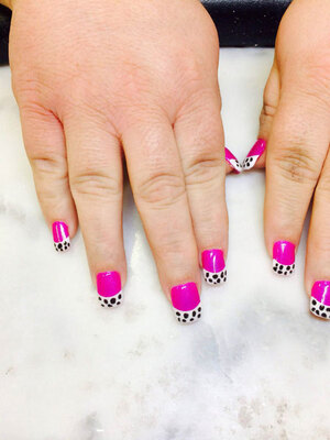 Female hands featuring painted nails in pink with spotted dalmation-print highlights is just one of the many style options available from Binh's Nails in Edmonton