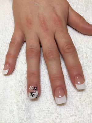 Polished fingernails in clear and white with flowered designs created by Binh's nail experts