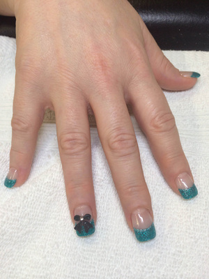 Polished nails with clear coat, blue tips with glitter and a 3D highlight is a great style from Binh's in edmonton