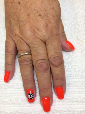 Orange nail polish with a hand-drawn artistic element is a great look from Binh's