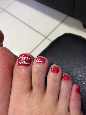 Red toenails with 3D jewel elements make a stunning fashion statement available at Binh's; the perfect place for a pedi